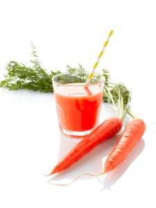 Fresh carrot juice and carrots on white background